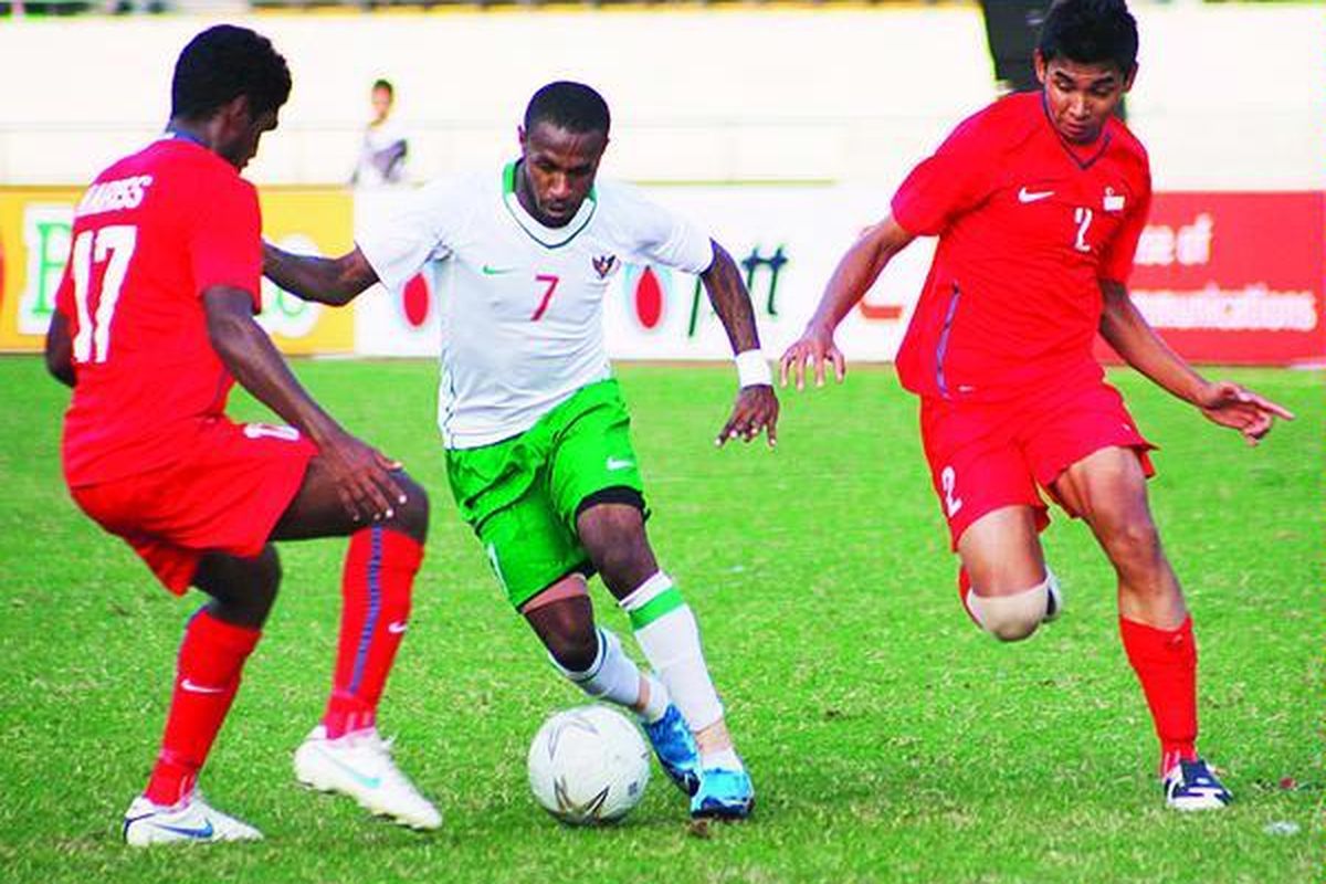 Penyerang tengah tim Indonesia, Boas Salossa (tengah), berupaya melewati pemain Singapura pada laga pertama Grup B SEA Games XXV Laos. Indonesia bermain imbang 2-2 dengan Singapura pada laga yang digelar di Stadion Nasional, Vientiane, Laos, Sabtu (5/12/09). Setelah itu, Indonesia kalah 0-2 dari Laos yang membuat posisinya sangat kritis.