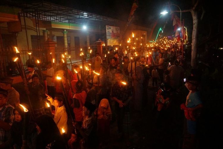 People carry bamboo torches aloft during takbiran, chanting Allah is great, on the eve of Idul Fitri.