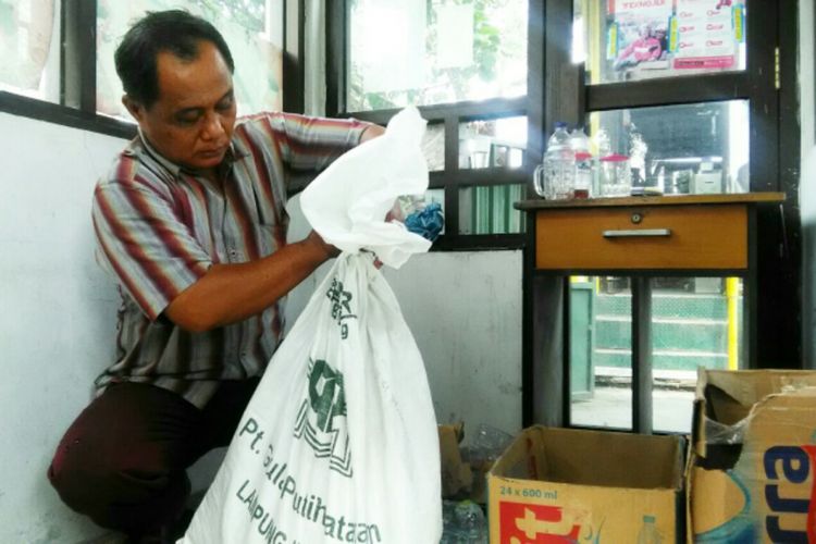 Antok saat menunjukan karung tempat menyimpan sementara ular yang berhasil di evakuasi dari atas platform rumah warga