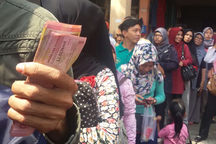 Warga antre menukarkan uang di Pasar Wates, Kulon Progo, Daerah Istimewa Yogyakarta. BI kerahkan satu minibus mobil kas keliling untuk membuka layanan penukaran uang ini.