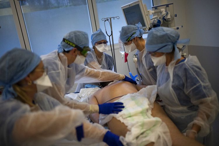 Pekerja medis menyerahkan pasien Covid-19 Perancis dengan ventilator di unit perawatan intensif Covis-19 di rumah sakit la Timone di Marseille, Perancis selatan, Jumat, 24 Desember 2021. 