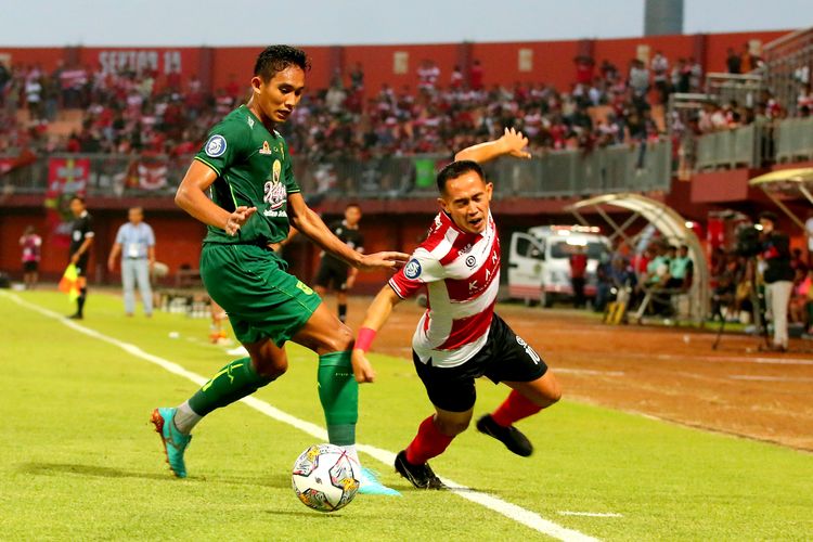 Pemain Persebaya Surabaya Rizky Ridho berhasil merebut bola pemain Madura United Slamet Nurcahyo saat pertandingan pekan ke-21 Liga 1 2022-2023 yang berakhir dengan skor 0-2 di Stadion Gelora Ratu Pamelingan Pamekasan, Minggu (29/1/2023) sore.