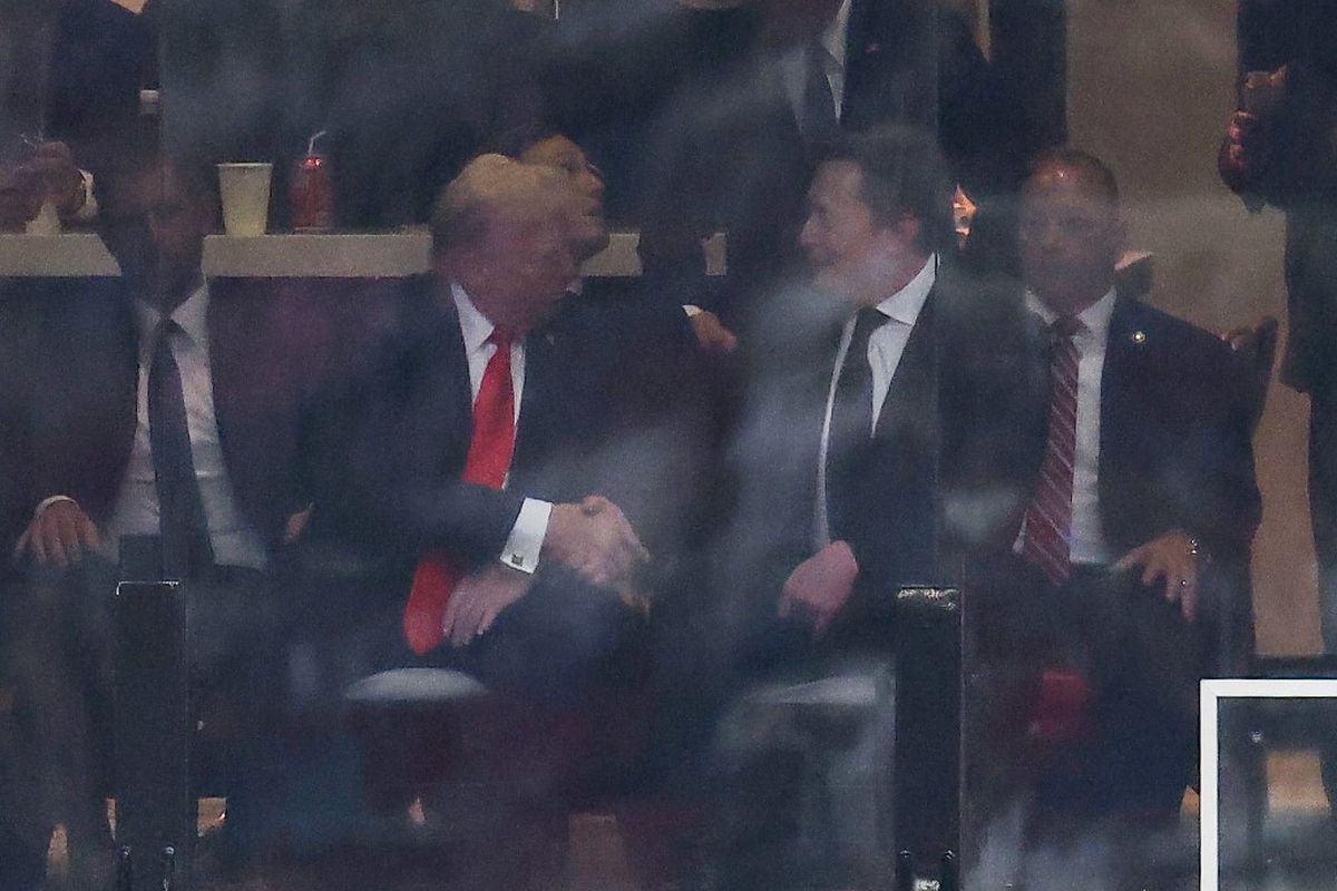 Presiden AS Donald Trump dan CEO Tesla Elon Musk berjabat tangan selama upacara peringatan publik untuk aktivis sayap kanan Charlie Kirk di State Farm Stadium di Glendale, Arizona, pada 21 September 2025.
