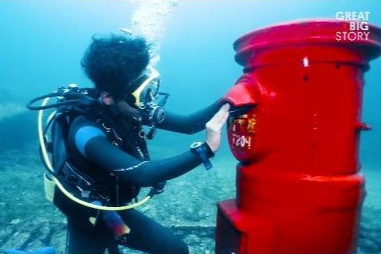 Penyelam memasukkan surat dalam kotak pos bawah laut di Susami, Jepang.