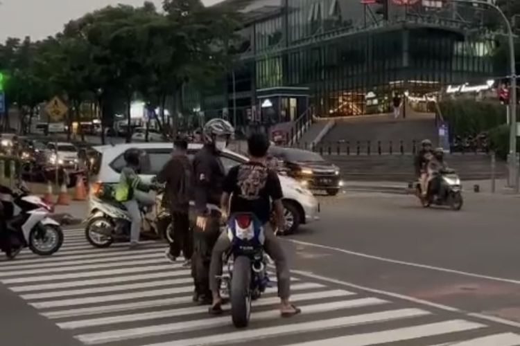 Seorang petugas patroli dari kepolisian mengambil kunci motor seorang remaja di Pondok Jaya, Kecamatan Pondok Aren, Tangsel. Motor yang dikendarai remaja tersebut telah dimodifikasi. Remaja itu tampak menggunakan kaus hitam, celana jeans.