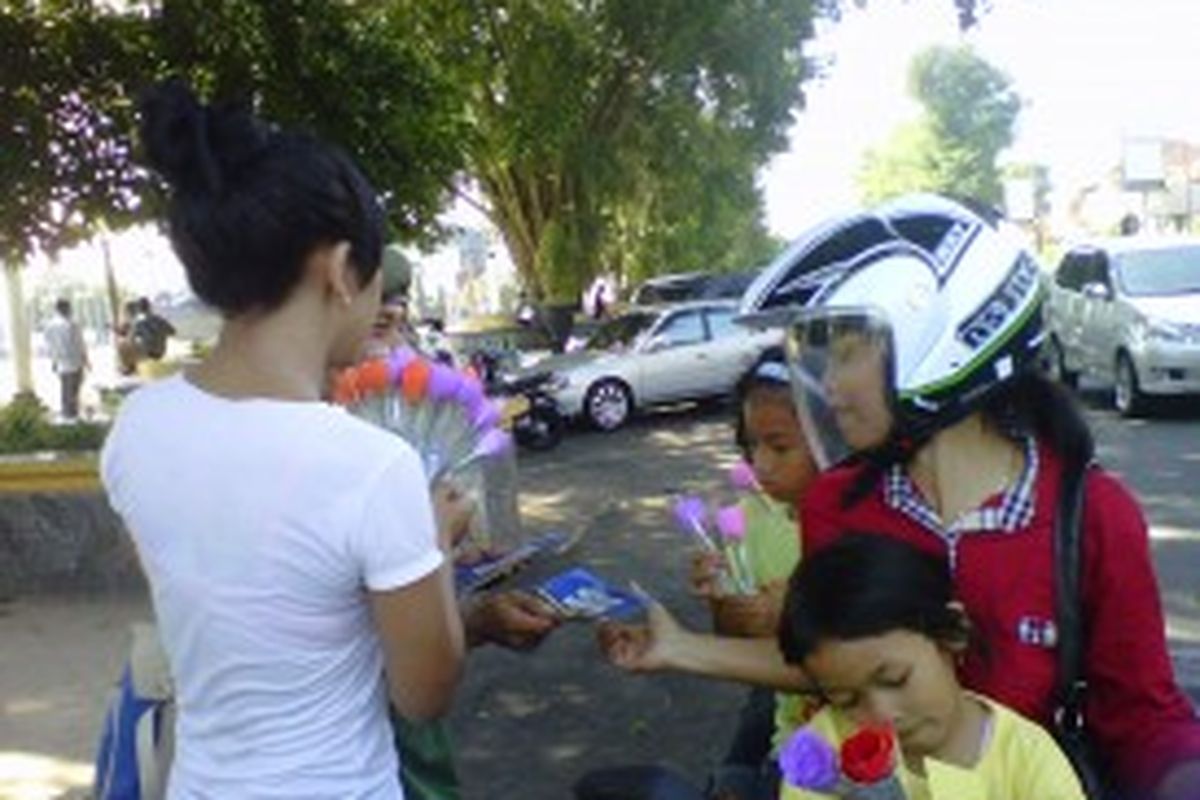 Salah seorang anggota komunitas Be Positif membagi-bagikan bunga dan stiker anti narkoba di kawasan alun-alun Kota Magelang, Rabu (26/6/2013).