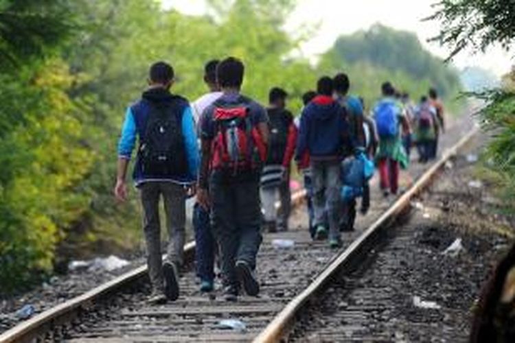 Para migran yang sebagian besar berasal dari Timur Tengah, menyusuri rel kereta api untuk menuju Hungaria dari wilayah Serbia.