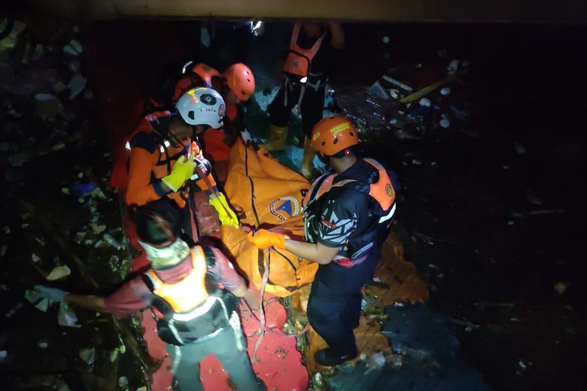 Petugas mengevakuasi jenazah korban berinisial MF (11) yang tersangkut di keramba apung kawasan Kembangan, Jakarta Barat, Senin (4/12/2023). 