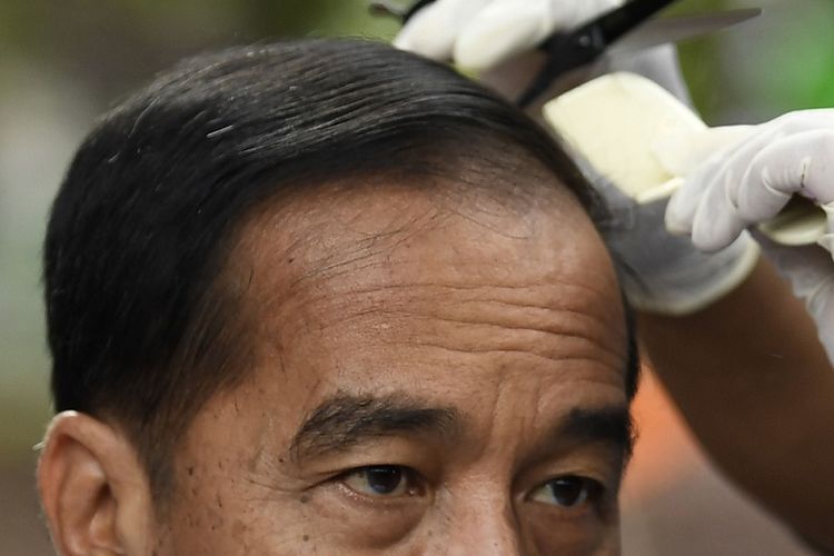 Presiden Joko Widodo mengikuti potong rambut massal di area wisata Situ Bagendit, Garut, Jawa Barat, Sabtu (19/1/2019). ANTARA FOTO/Puspa Perwitasari/foc.