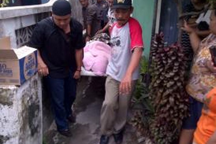 Petugas dan warga menandu jasad Sukarno menuju mobill jenazah usai ditemukan tewas di kamar kosnya Kelurahan Ngadirejo, Kota Kediri, Jawa Timur, Rabu (27/11/2013). 