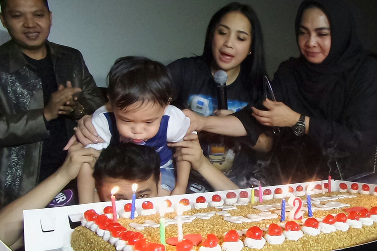 Rafathar Malik Ahmad bersama kedua orangtuanya, artis peran Nagita Slavina dan Pembawa acara Raffi Ahmad serta sang nenek Mama Rita saat prosesi tiup lilin di Setiabudi One, Kuningan, Jakarta Selatan, Selasa (15/8/2017).