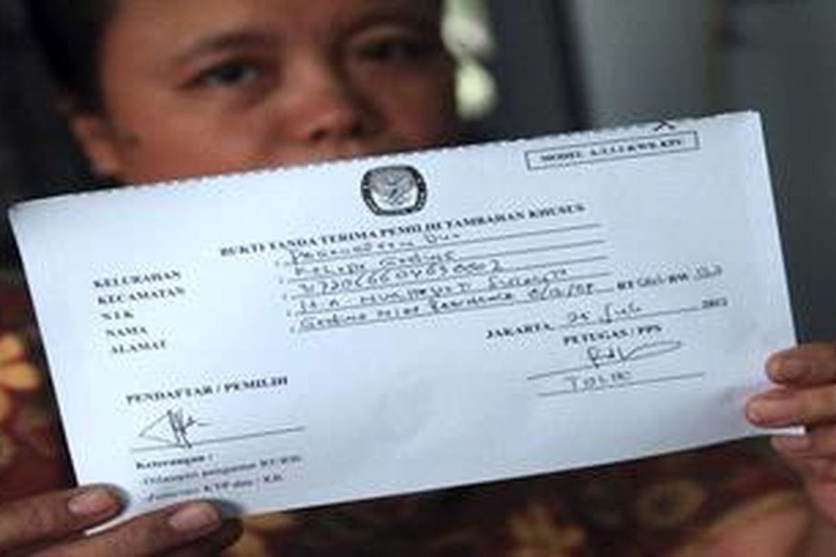 Warga Apartemen Gading Nias, Nurhayati, menunjukkan tanda terima pendaftaran pemilih tambahan khusus usai mendaftarkan diri di PPS Kelurahan Pegangsaan Dua, Kelapa Gading, Jakarta Utara, Rabu (25/7/2012). 