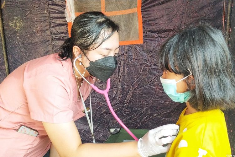 Seorang anak penyintas bencana banjir diperiksa dokter di Pos Kesehatan, Kampung Tugu, Baros, Sukabumi, Jawa Barat, Sabtu (19/2/2022).