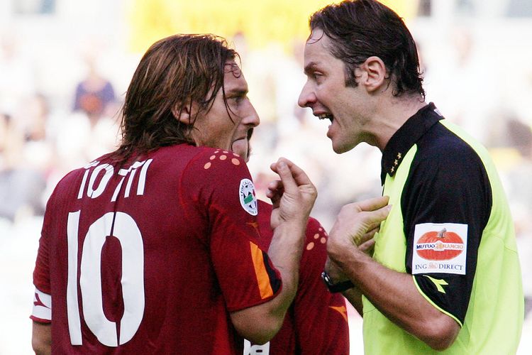 Kapten AS Roma Francesco Totti (kiri) beradu argumen dengan wasit ketika pertandingan Serie A melawan Palermo di Olimpico, Roma, 24 Oktober 2004, yang berakhir dengan skor 1-1. Totti melakukan gestur tangan khas orang Italia yang bermakna mempertanyakan maksud lawan bicara.