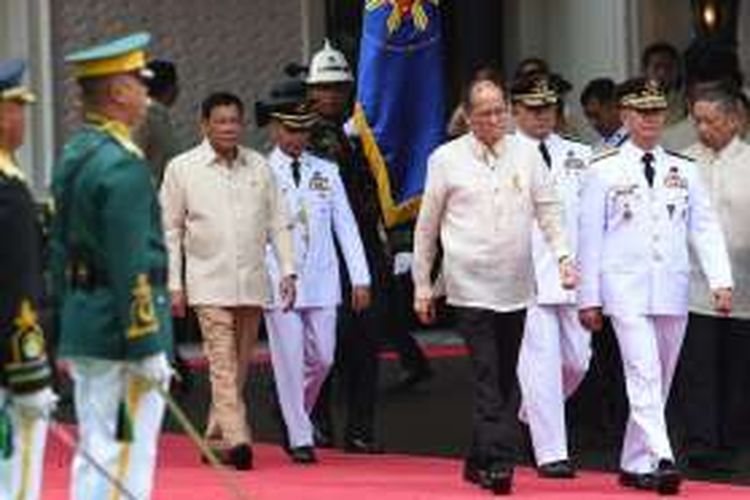 Presiden baru Filipina, Rodrigo Duterte berjalan di belakang pendahulunya Benigno Aquino menjelang seremoni pelepasan di Istana Malacanang, Kamis (30/6/2016).