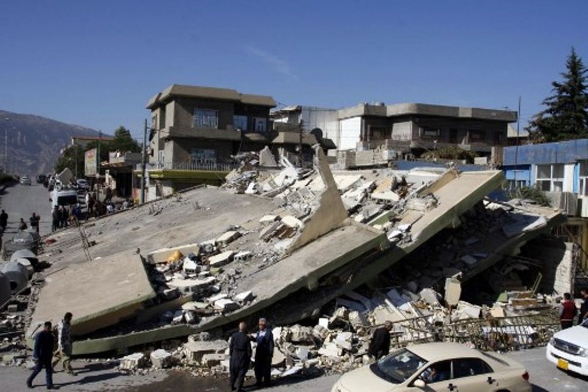 Orang-orang mengerumuni sebuah gedung bertingkat yang hancur akibat gempa berkekuatan 7,3 SR, di perbatasan Irak-Iran, Senin (13/11/2017). (AFP/Shwan Mohammed)
SHWAN MOHAMMED 