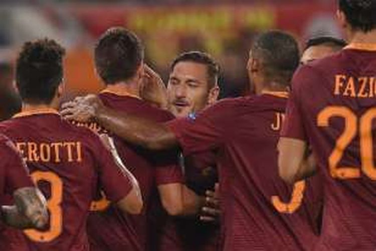 Francesco Totti mendapat pelukan dari rekan-rekannya seusai menjadi kreator gol AS Roma ke gawang Astra pada laga Liga Europa di Stadion Olimpico, Kamis (29/9/2016). 