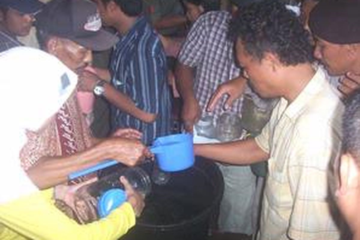 Massa antre mendapatkan air yang dari ember yang sudah didoakan oleh Slamet ayah Dewi Sulistiawati