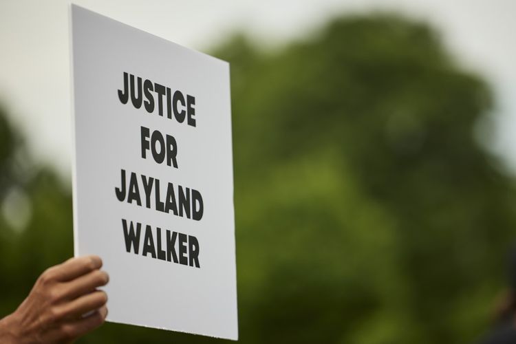 Seorang demonstran pada 8 Juli 2022 membawa papan bertuliskan pesan menuntut keadilan atas kematian Jayland Walker, pria kulit hitam yang tewas ditembak polisi di kota Akron, negara bagian Ohio, Amerika Serikat, pada 3 Juli 2022/