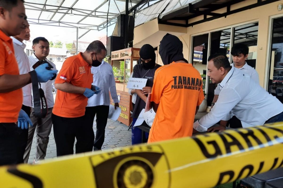 Dua pelaku pembunuhan terhadap AE, siswi SMP di Kabupaten Mojokerto, Jawa Timur, memeragakan adegan membuang jasad korban, saat rekonstruksi di Mapolres Mojokerto Kota, Senin (19/6/2023.