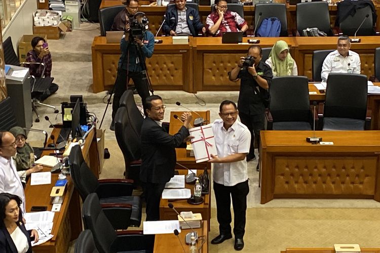 Menteri Dalam Negeri (Mendagri) Tito Karnavian (kanan) berdiri di samping Ketua Baleg DPR Supratman Andi Agtas saat proses penyerahan Daftar Inventarisasi Masalah (DIM) untuk Rancangan Undang-undang Daerah Khusus Jakarta (RUU DKJ) dalam rapat di Gedung DPR, Senayan, Jakarta, Rabu (13/3/2024).