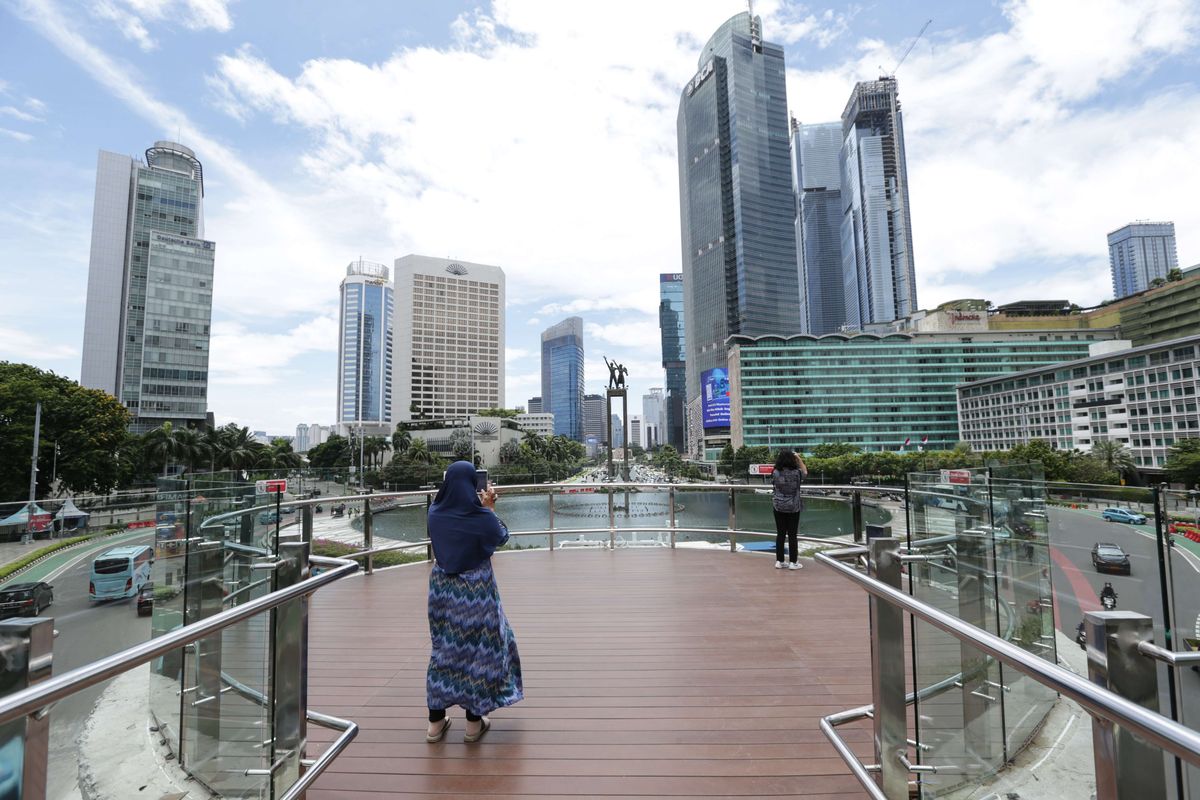 Pengunjung berfoto di anjungan Halte Transjakarta Bundaran Hotel Indonesia, Jakarta, Jumat (28/10/2022). Warga Ibu Kota datang ke halte yang belum sepenuhnya rampung itu untuk antre berfoto demi dapat latar belakang Patung Selamat Datang.