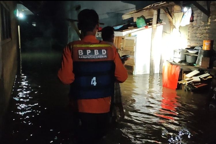 BPBD Kabupaten Cirebon Jawa Barat bersama TNI Polri memberikan bantuan kepada korban terdampak banjir, di Desa Gamel, Kecamatan Plered, Kabupaten Cirebon pada Selasa malam (20/12/2022)