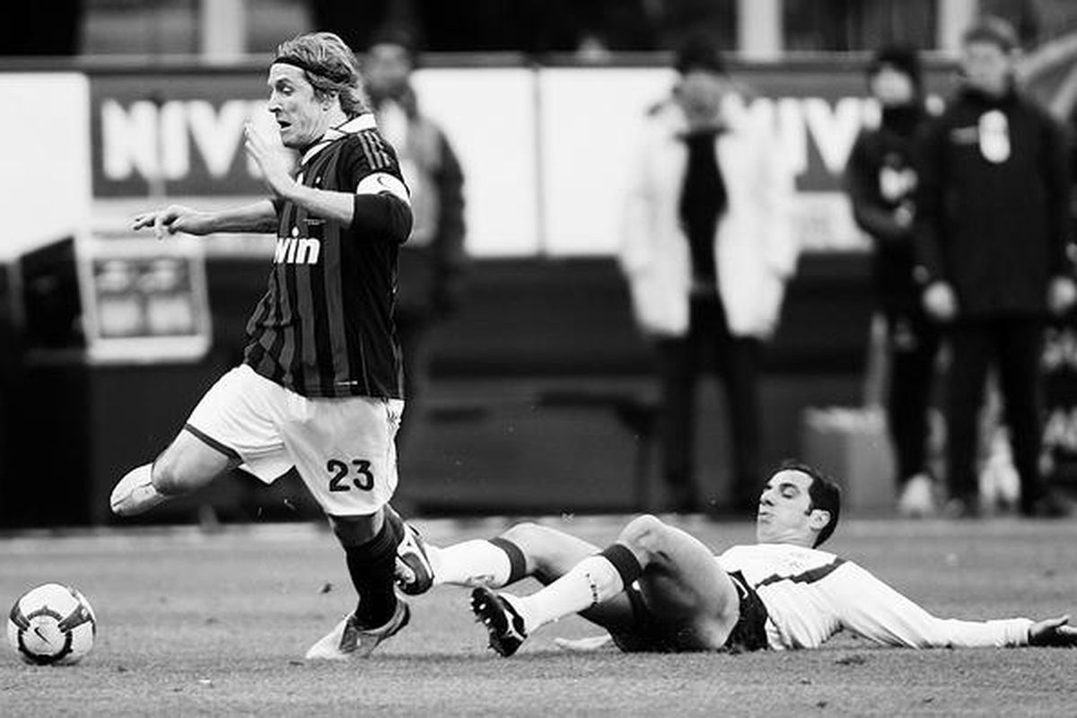 Gelandang AC Milan, Massimo Ambrosini (kiri), terjatuh diganjal penyerang Livorno, Claudio Bellucci, pada laga Serie A Italia di Stadion San Siro, Milan, Italia, Minggu (31/1). Kedua tim bermain imbang 1-1.