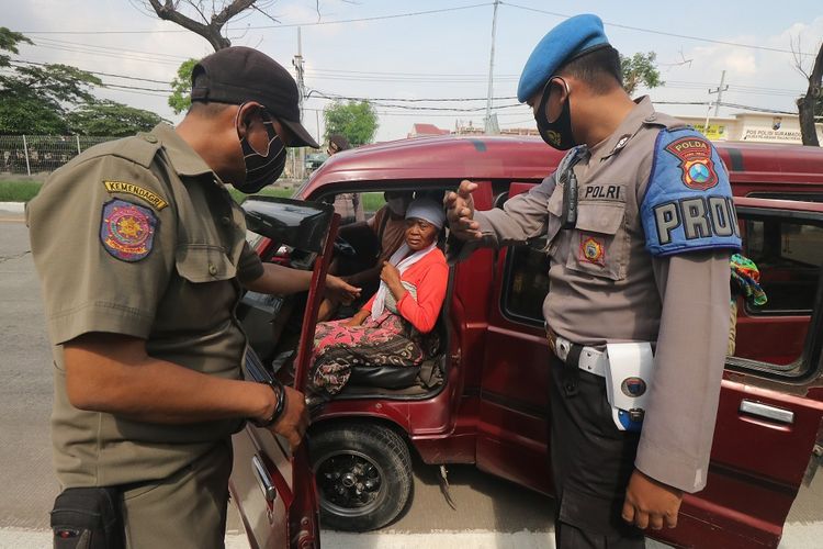 Petugas menindak warga yang terjaring razia protokol kesehatan di akses keluar Jembatan Suramadu, Surabaya, Jawa Timur, Rabu (2/12/2020). Razia yang bertujuan untuk meningkatkan kedisiplinan dalam penerapan protokol kesehatan itu menjaring sejumlah warga yang tidak mengenakan masker dengan benar maupun tidak mengenakan masker sama sekali. ANTARA FOTO/Didik Suhartono/aww.