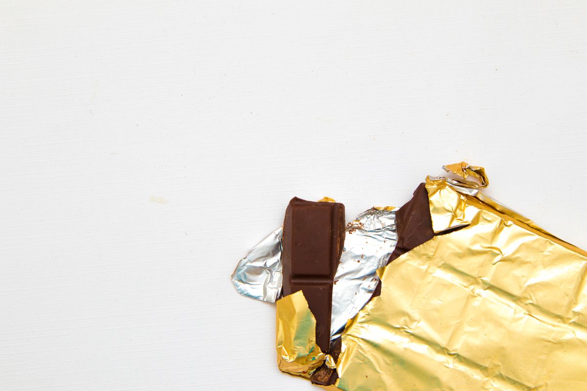 Ilustrasi cokelat batang yang dibungkus dengan alumunium foil.