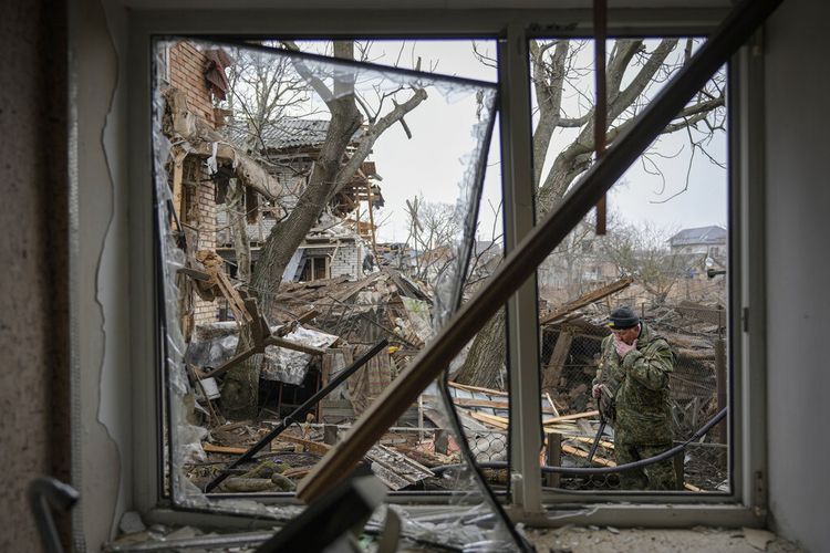 Andrey Goncharuk, 68, seorang anggota pertahanan teritorial menyeka wajahnya di halaman belakang sebuah rumah yang dirusak oleh serangan udara Rusia, menurut penduduk setempat, di Gorenka, di luar ibu kota Kyiv, Ukraina, Rabu, 2 Maret 2022. 