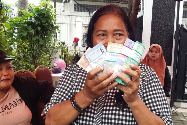 Suprapti (58), warga Bibis Kulon, Kecamatan Banjarsari, Solo, Jawa Tengah menunjukkan uang rupiah baru yang dia tukarkan di mobil layanan Bank Indonesia Solo di depan halaman Kantor Kecamatan Banjarsari, Jumat (15/3/2024).