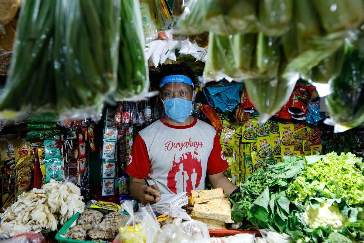 Udin (43), pedagang di Pasar Sukasari menggunakan face shield saat berdagang, Jumat (5/6/2020). Kementerian Perdagangan menyiapkan pedoman penyelenggara kegiatan perdagangan untuk diterapkan pada saat kenormalan baru dimana pedagang di pasar rakyat diwajibkan menggunakan masker, face shield, dan sarung tangan selama beraktivitas.