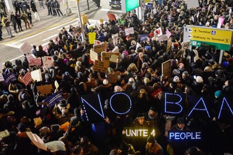 Ratusan warga AS menggelar unjuk rasa di bandara internasional John F Kennedy, New York setelah aparat keamanan bandara menahan 11 orang pengungsi yang mendarat di bandara itu.