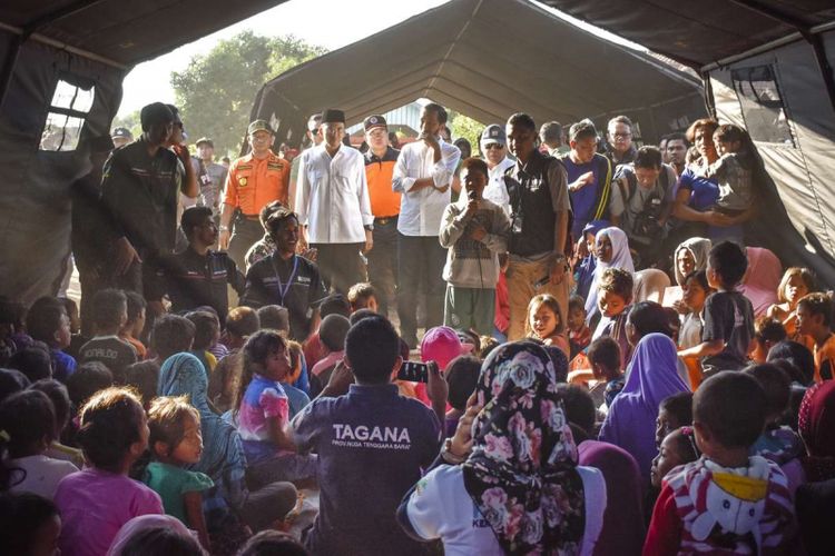 Presiden Joko Widodo (tengah) didampingi Gubernur NTB TGB Zainul Majdi (kedua kiri) berdialog dengan anak-anak korban gempa di Desa Madayin, Kecamatan Sambelia, Selong, Lombok Timur, NTB, Senin (30/7/2018). Presiden Jokowi mengatakan pemerintah akan memberikan bantuan untuk perbaikan Rp 50 juta per rumah korban gempa yang mengalami kerusakan.