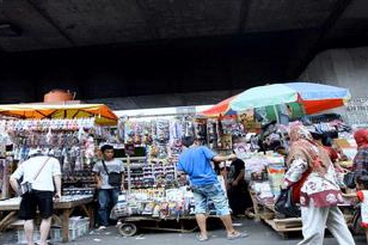 Warga berbelanja aneka kebutuhan yang dijual pedagang kaki lima di Kawasan Pasar Pagi Asemka, Jakarta Barat, Selasa (6/11/2012). Banyak pedagang kaki lima berharap agar biaya sewa lapak tidak terlalu mahal jika nantinya harus pindah ke dalam pasar.

