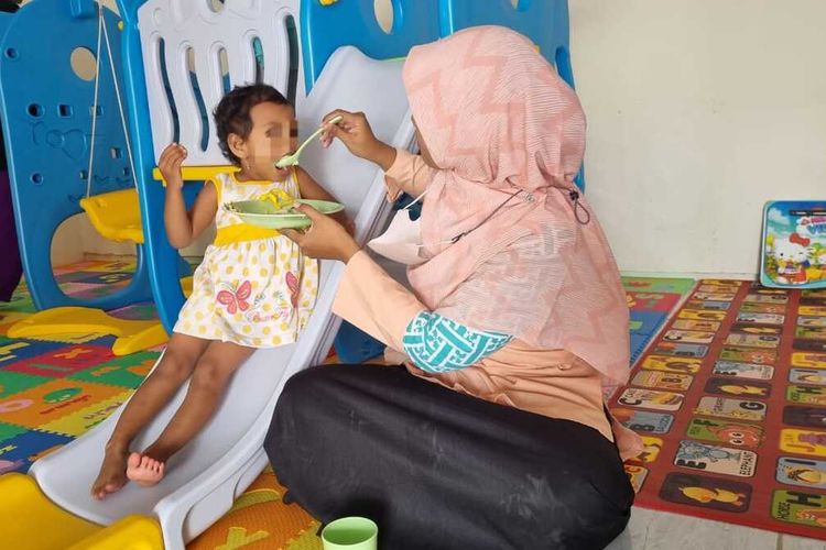 Pengasuh di daycare Rumah Pelita milik Pemkot Semarang menyuapi anak-anak yang dititipkan orangtuanya, Senin (3/4/2023).