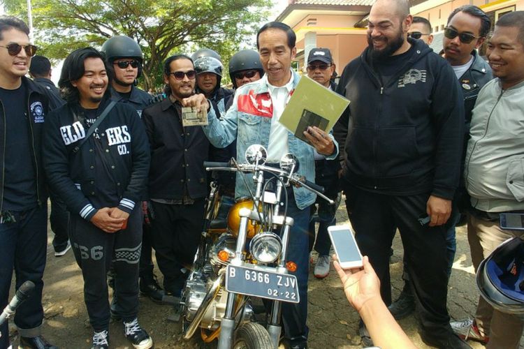 Presiden Joko Widodo memperlihatkan dokumen dan kelengkapan berkendara sebelum menjajal sepeda motor chopper miliknya di Sukabumi, Jawa Barat, Minggu (8/4/2018).