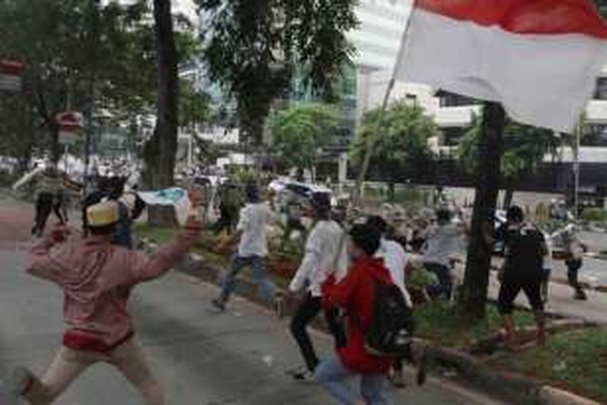 Massa demonstran berlarian mengejar polisi saat terjadi bentrokan dengan polisi di depan kantor KPK, Jakarta, Jumat (20/5/2016). Bentrokan terjadi saat massa dari Aliansi Masyarakat Jakarta Utara mendesak masuk ke gedung KPK untuk mendesak pemeriksaan terhadap Gubernur DKI Jakarta Basuki Tjahaja Purnama (Ahok). 