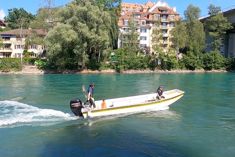 Dua petugas polisi Bern tengah berpatroli menggunakan kapal di sekitar Schoenausteg, Sungai Aare, Bern, Siwss pada Selasa (31/5/2022).