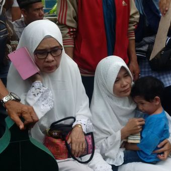 Rohana (430 istri Tri bersama putra bungusnya saat menyaksikan pemakaman sumainya di TPU Kamboja, Palembang