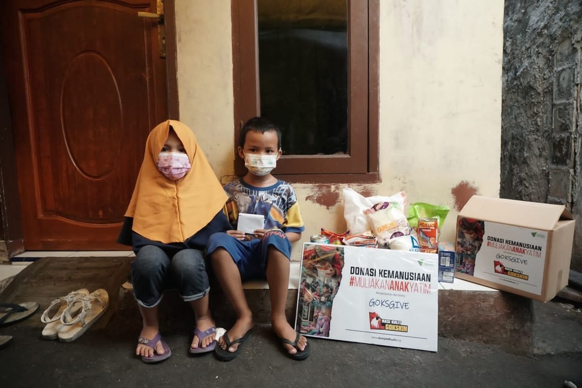 Putra dan Cahaya, penerima manfaat donasi kemanusiaan Muliakan Anak Yatim Dompet Dhuafa, saat menerima paket bantuan, beberapa waktu lalu.
