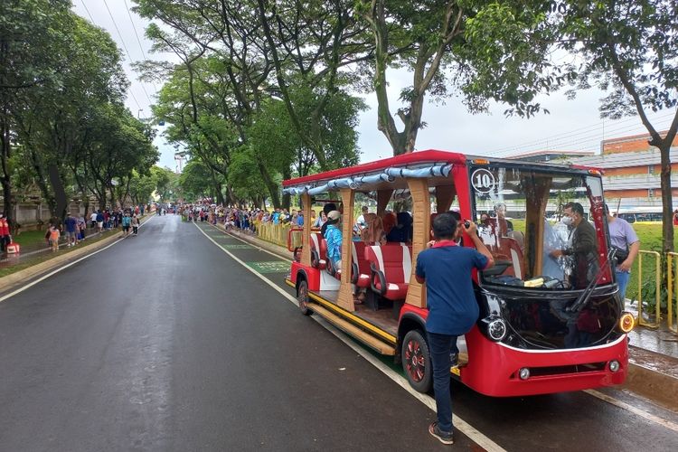 Antrean pengunjung mengular di shuttle bus gratis Taman  Mini Indonesia, Cipayung, Jakarta Timur, Minggu (1/1/2023).