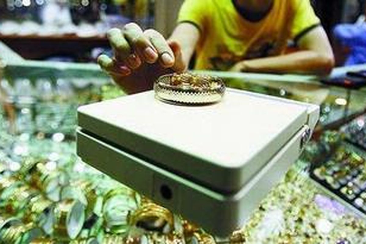 Pedagang emas di Pasar Tebet, Jakarta Selatan, menimbang perhiasan.