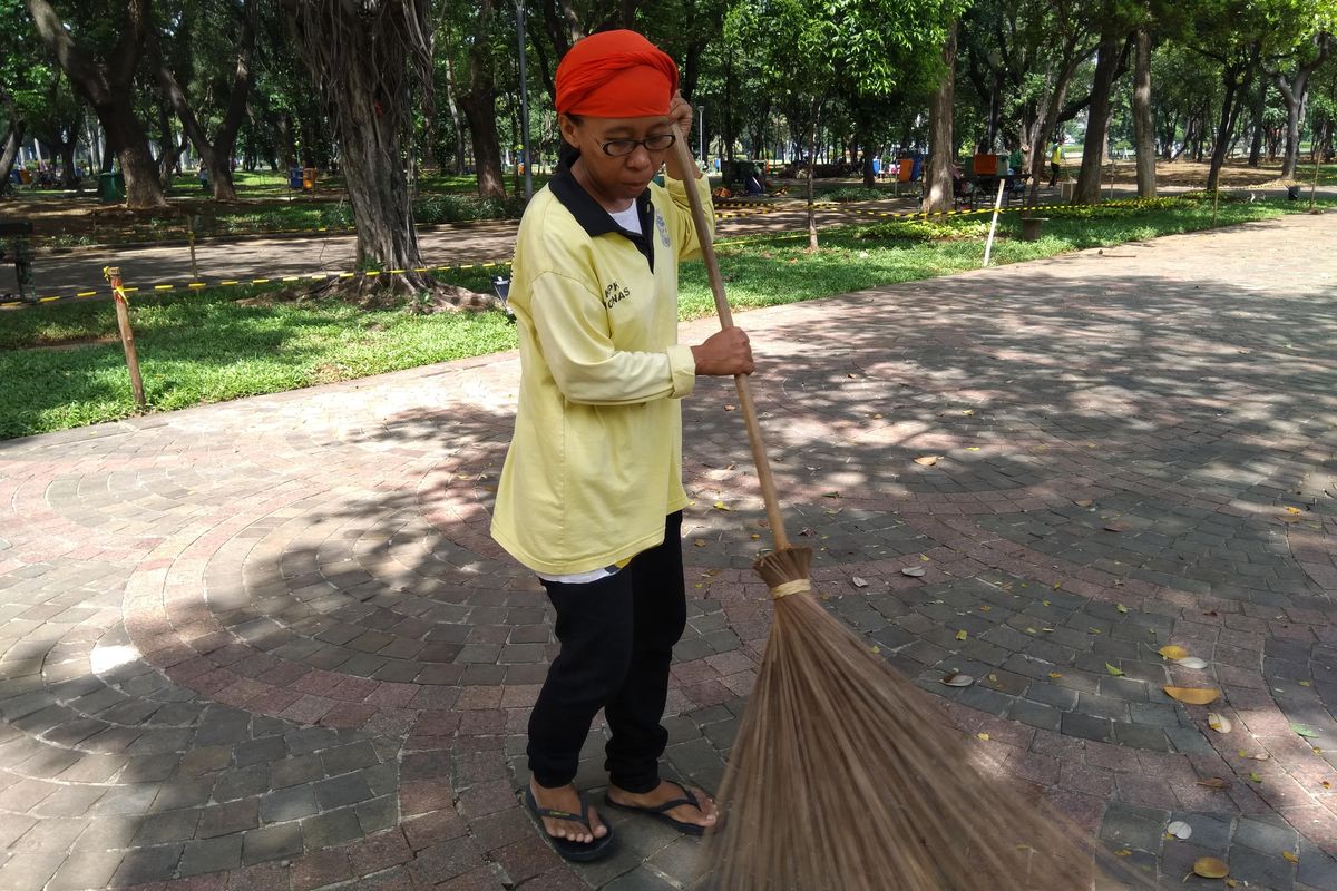 Siska (42) Petugas Kebersihan Monas sedang menyapu sebelum berbagi pengalaman tentang proses pembersihan sampah sisa perayaan tahun baru yang biasa dilakukan di Monas.