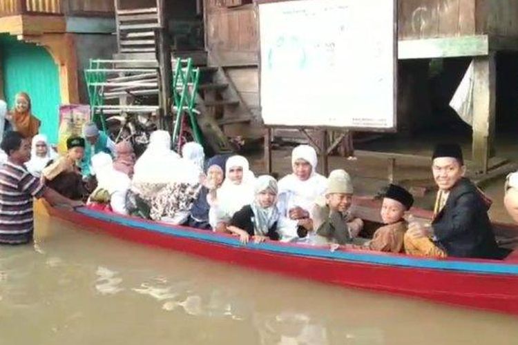 Warga naik perahu biduk untuk melaksanakan salat Idul Fitri berjamaah di Masjid Asy-Syuhada Desa Mandi Angin, Kecamatan Rawas Ilir, Kabupaten Muratara, Rabu (10/4/2024). 