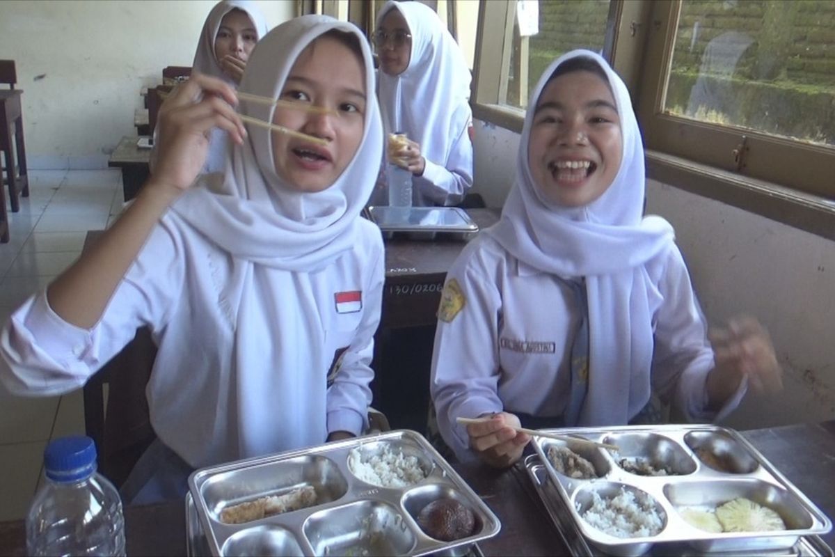 Salah satu cara menikmati program makan bergizi gratis (MBG), siswa SMK kelas XII jurusan perkantoran, makan pakai sumpit ala drakor. SMK 1 Mataram termasuk sekolah pertama yang menjadi tempat pelaksanaan MBG di Mataram, Senin (13/1/2025) untuk 977 siswa.