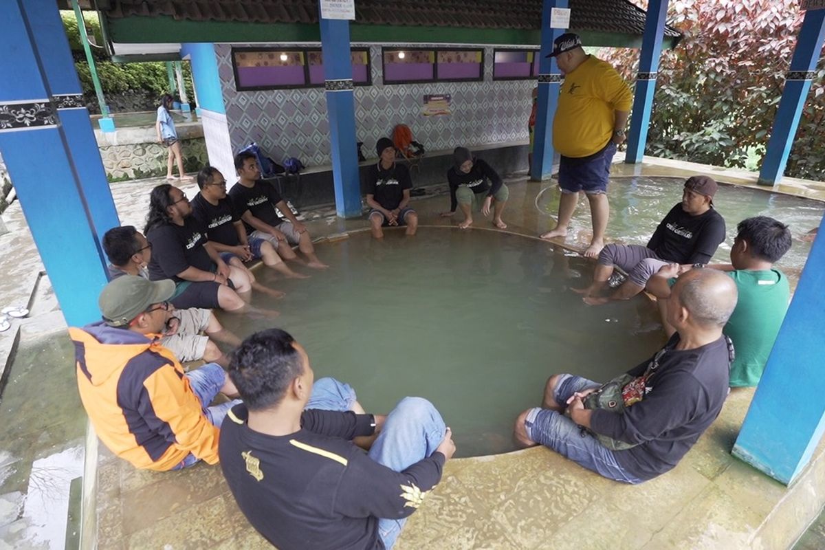 Pendaki Gunung Ijen merendam kakinya di kolam air panas Blawan, Sabtu (8/7/2023).