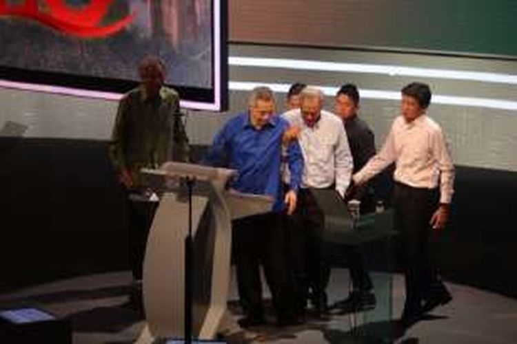 Perdana Menteri Singapura Lee Hsien Loong dibantu berjalan oleh Menteri Pertahanan Ng Eng Hen setelah mendadak tidak sehat ketika sedang menyampaikan pidato kenegaraan, Minggu (21/08)