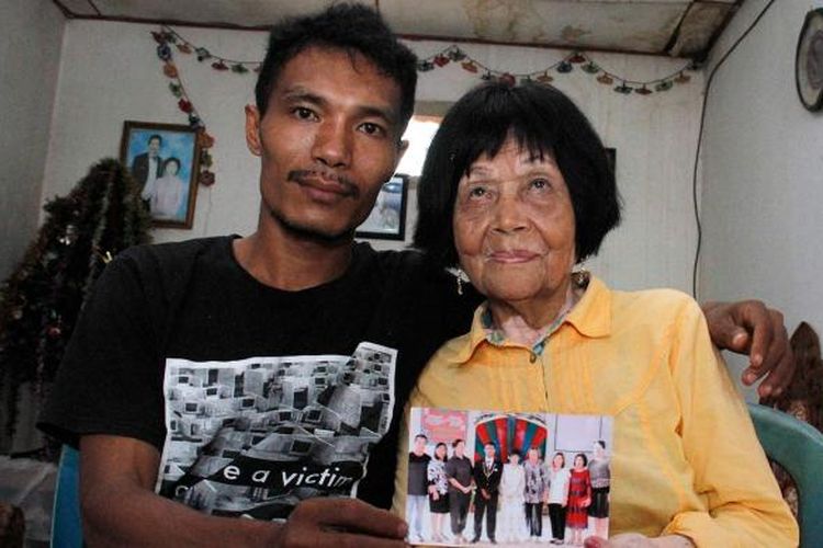 Sofian pemuda berusia 28 tahun memperlihatkan foto pemberkatan nikahnya dengan Martha, nenek yang berusia 82 tahun di Minahasa Selatan, Sulawesi Utara.